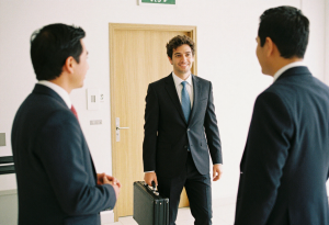 Tres profesionales están dialogando dentro de una oficina sobre el talento y la evaluación de los candidatos para su contratación.